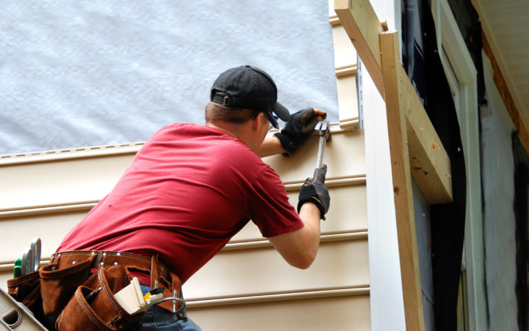 Contractor installing siding on a home